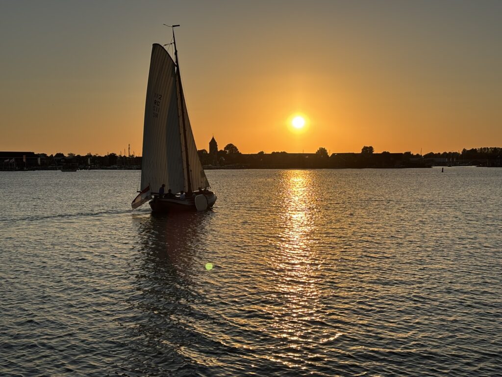 Zeilboot bij zonsondergang op het Sneekermeer tijdens een avondvaart